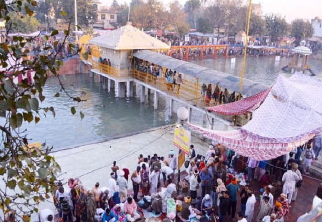 pitru dosh nivaran ritual being performed at the sacred Pehowa Ghat by experienced Vedic pandits. Devotees gathering for traditional pind daan ceremonies for ancestral peace and blessings.
